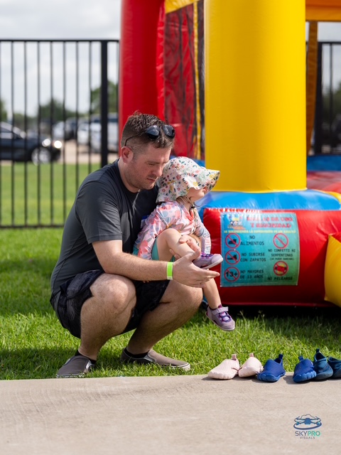 Dad helping his daughter at a bounce house